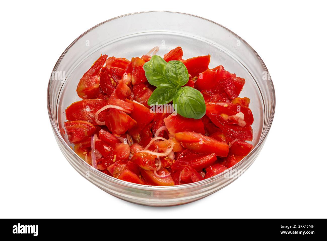 Salade de tomates crues coupées avec des tranches d'oignon habillées d'huile d'olive et de feuilles de basilic dans un bol en verre isolé sur blanc, chemin de détourage inclus Banque D'Images