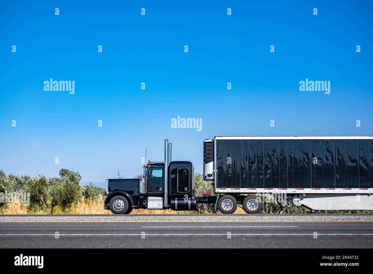 Tracteur semi-camion industriel long porteur noir BIG RIG avec cabine allongée pour le repos du conducteur de camion transportant des marchandises dans le réfrigérateur semi Trail Banque D'Images