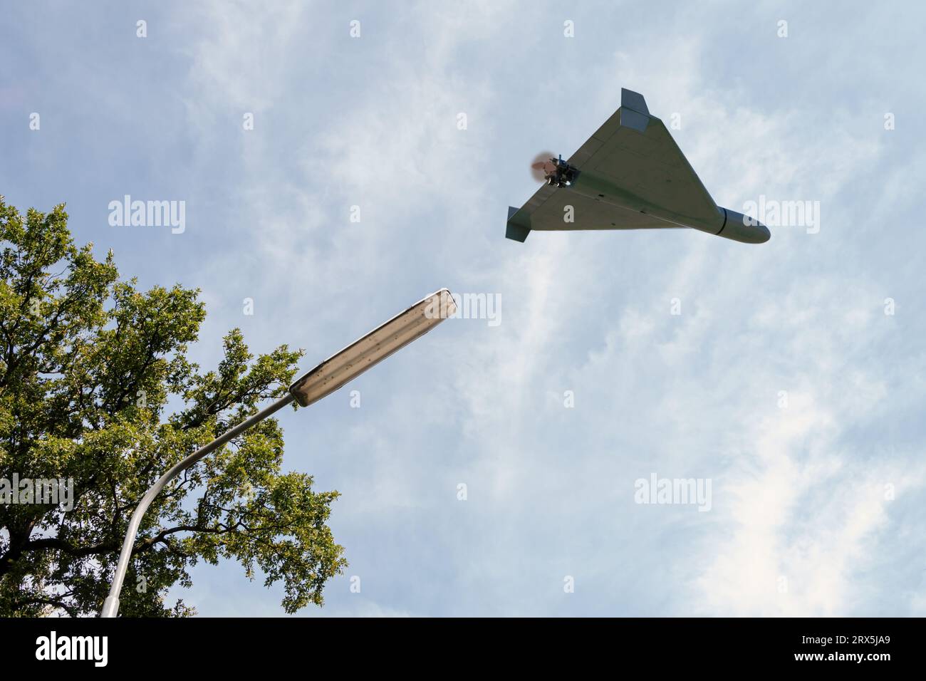 Shahed drone de combat volant au-dessus de l'éventail de la ville et du ciel, vue d'en bas, attaque de drone sur les installations et les infrastructures électriques, guerre en Ukraine, rendu 3D. Banque D'Images