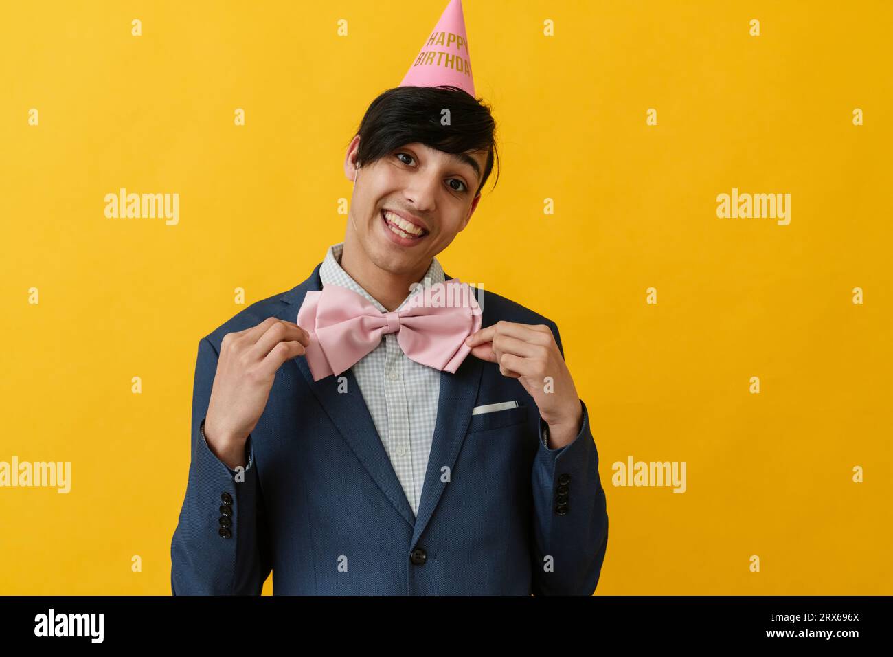 Homme joyeux portant noeud papillon et chapeau de fête pour l'anniversaire Banque D'Images
