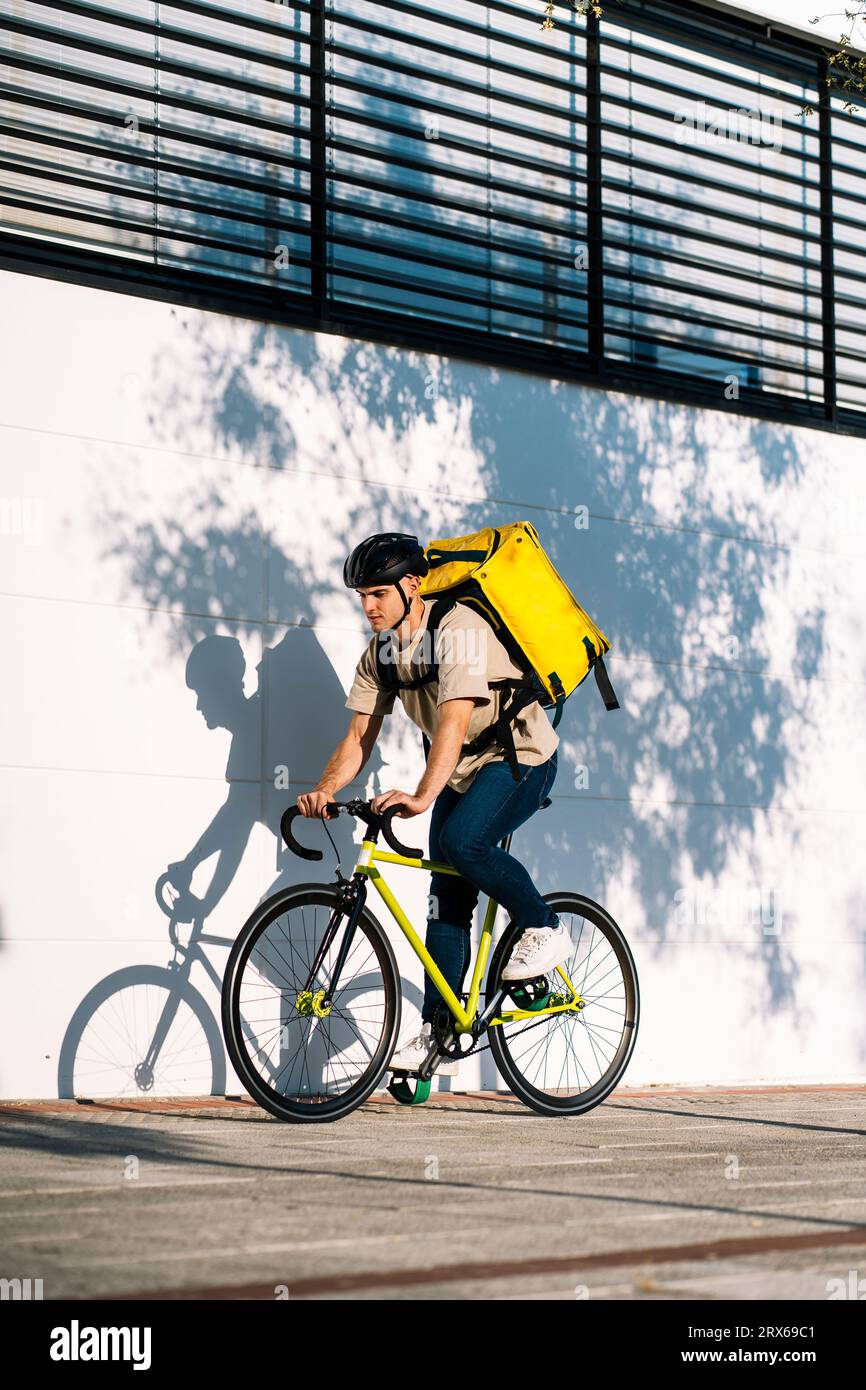 Livreur à vélo le jour ensoleillé Banque D'Images