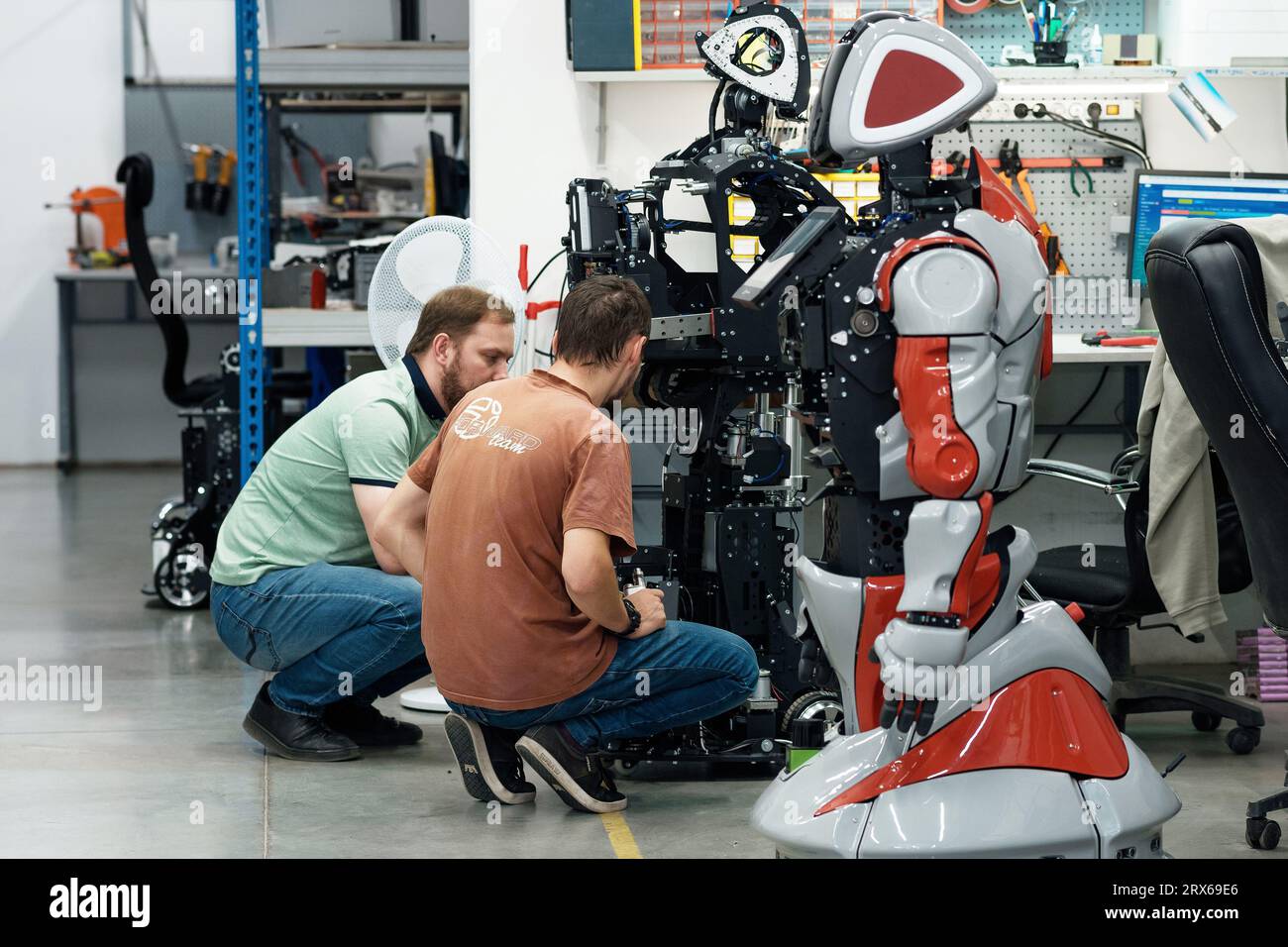 Perm, Russie - 13 juillet 2023 : des ingénieurs en robotique discutent des problèmes de travail dans un atelier d'assemblage de robots Banque D'Images