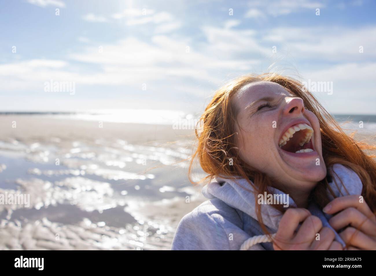 Femme riant à la plage en vacances Banque D'Images