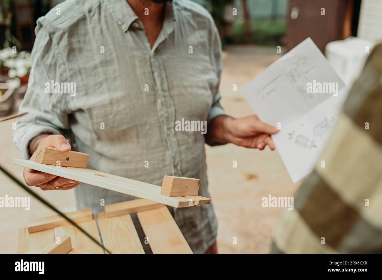 Homme tenant le manuel d'instruction et planche de bois Banque D'Images