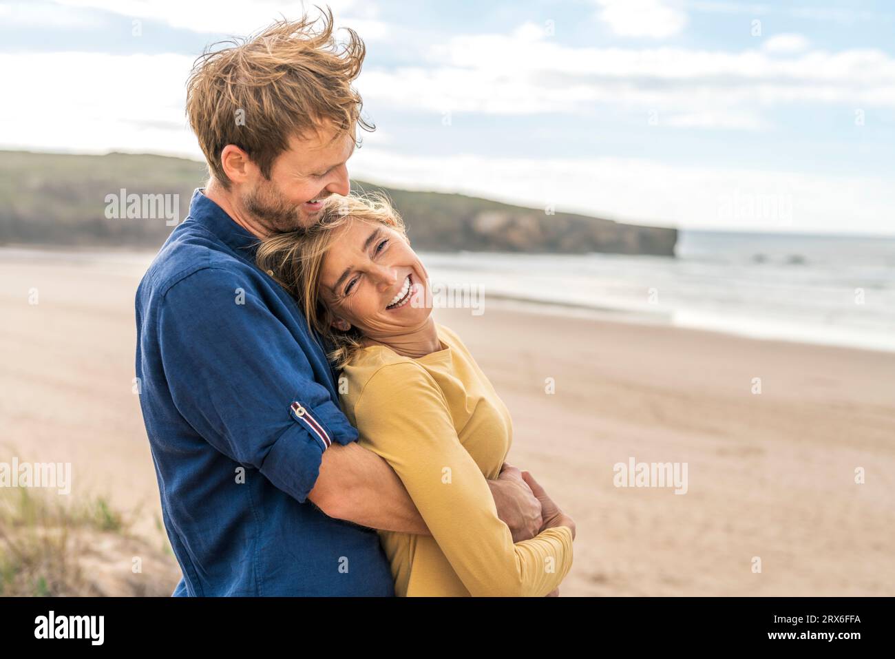 Joyeux couple amoureux debout à la plage Banque D'Images