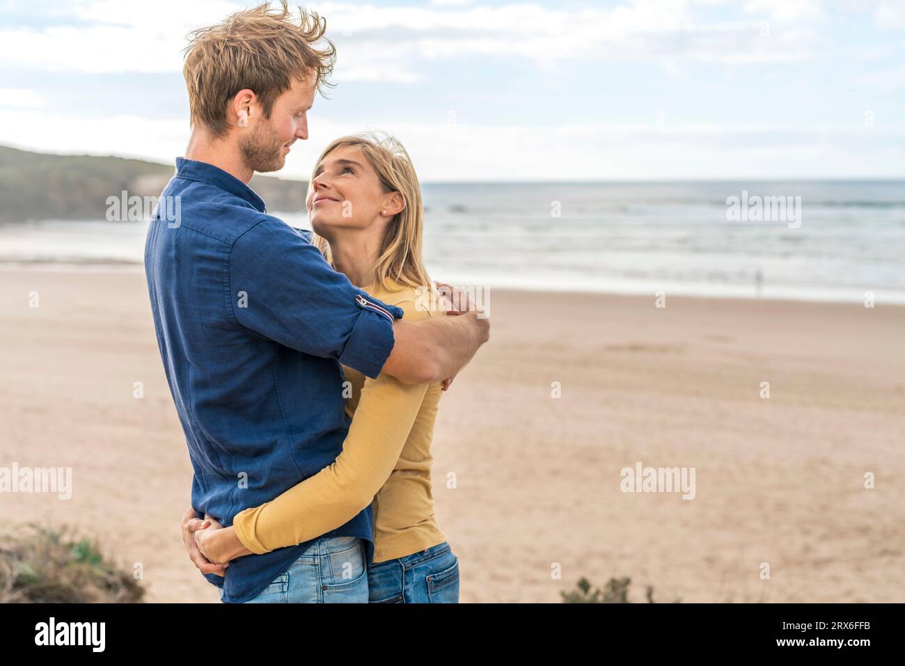 Femme souriante et homme se regardant face à la mer Banque D'Images