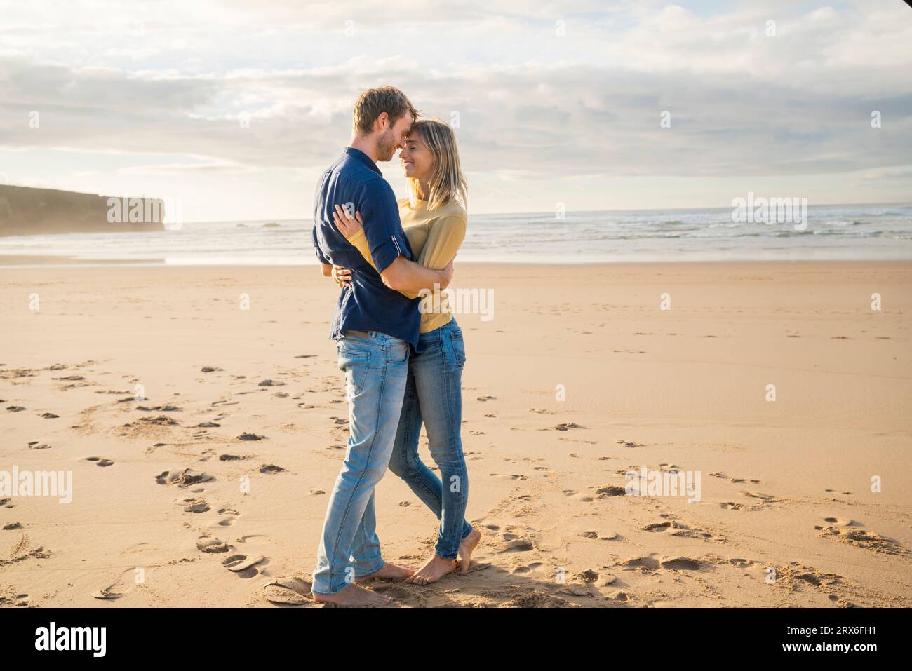 Femme et homme heureux s'embrassant à la plage Banque D'Images