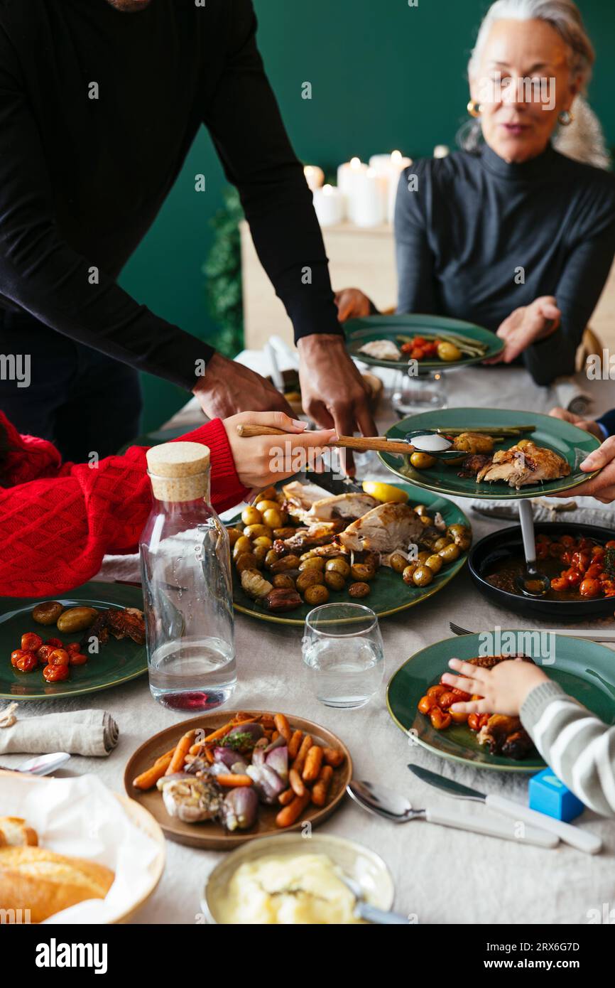 Famille ayant de la nourriture au dîner à Noël Banque D'Images
