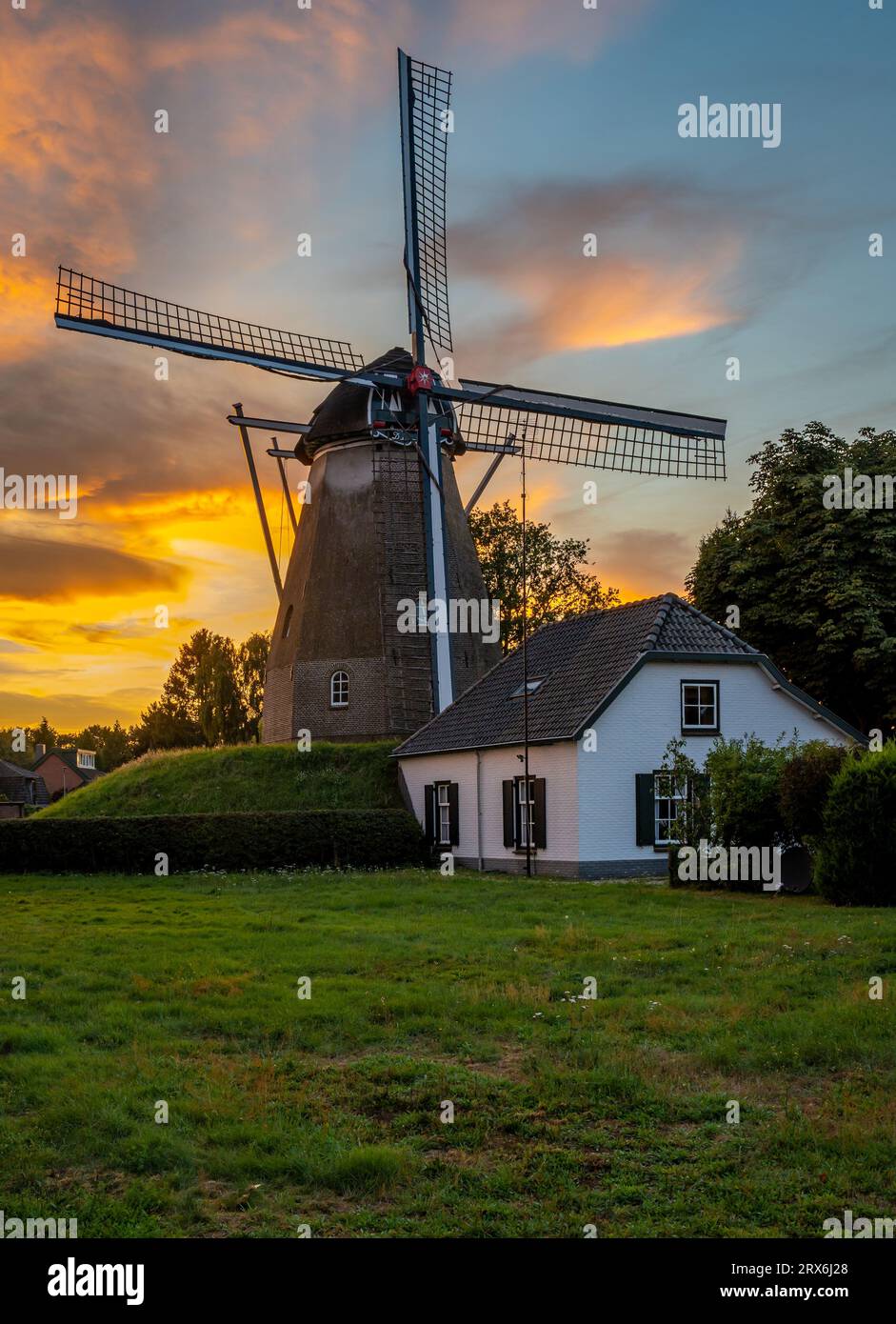 Plan vertical du moulin à vent hollandais traditionnel dans la ville d'Ede, province de Gelderland, par coucher de soleil coloré Banque D'Images