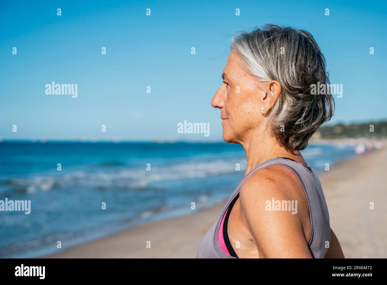 Femme mature avec les cheveux gris regardant la mer Banque D'Images