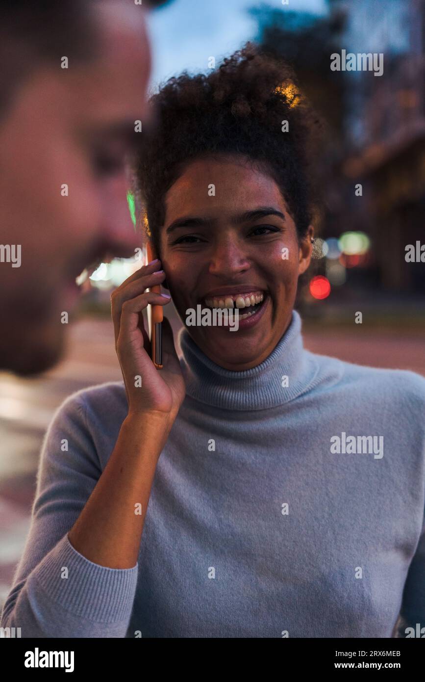 Une jeune femme heureuse qui parle sur un smartphone Banque D'Images