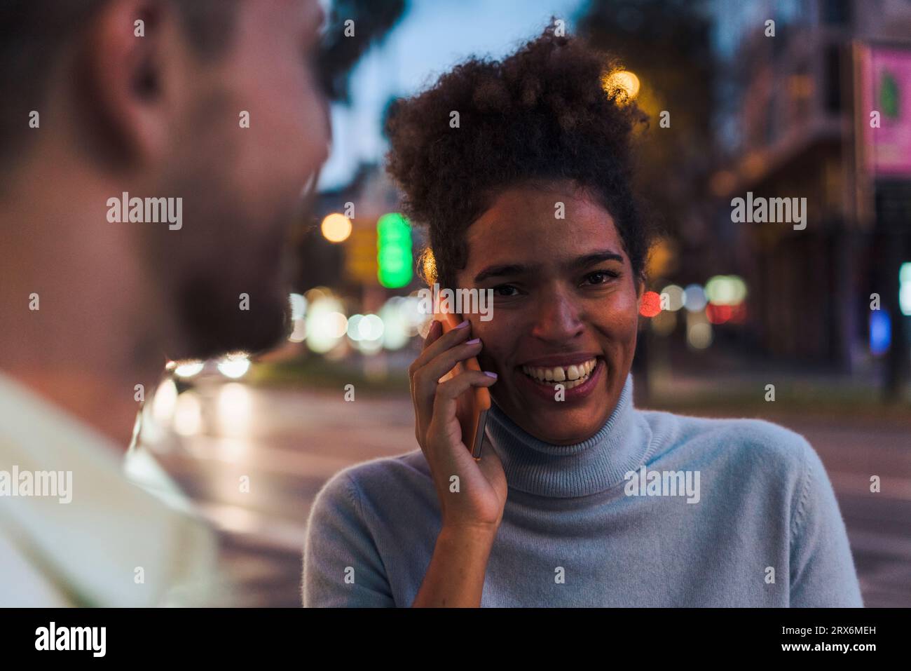 Smiling young woman talking on smart phone Banque D'Images