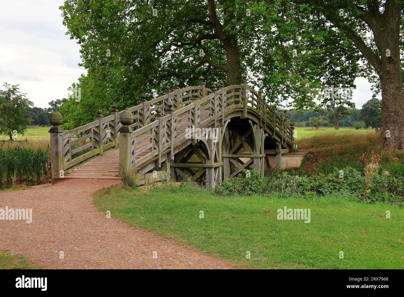 Piste de gravier menant à un pont chinois en bois à Croome Park dans le Gloucestershire, en Angleterre Banque D'Images