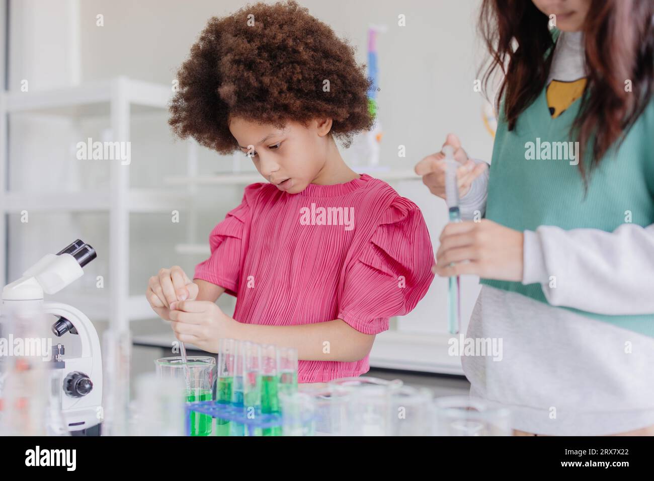 Afro enfants noirs diversité jouant dans le laboratoire de science chimique pour l'apprentissage de l'éducation à l'école avec un ami Banque D'Images