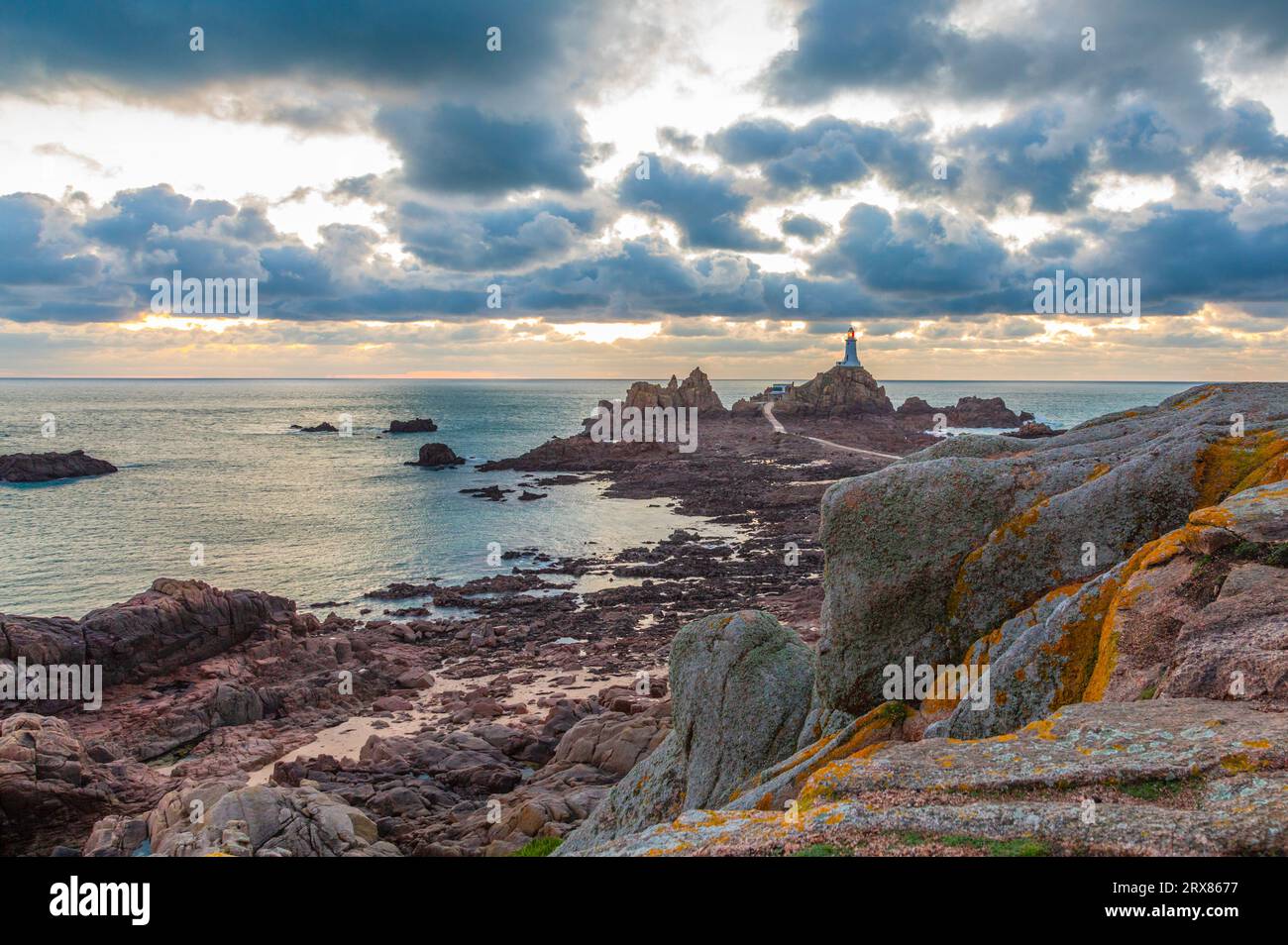 Route vers le phare de la Corbière au fond de la mer à marée basse avec falaise et coucher de soleil, bailliage de Jersey, îles Anglo-Normandes, Grande-Bretagne Banque D'Images