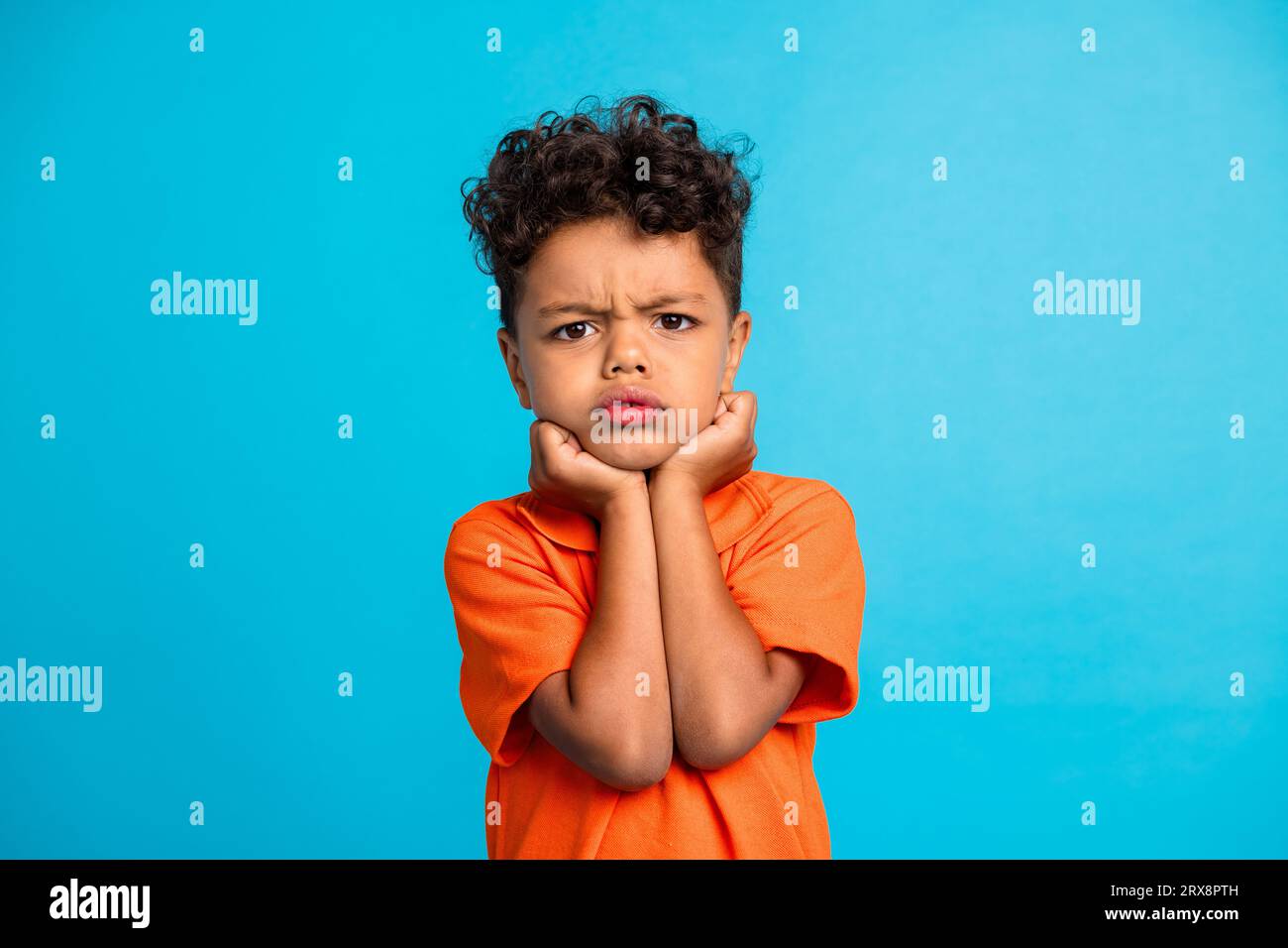 Photo de garçon d'enfant insatisfait se sentant en colère isolé sur fond de couleur bleue Banque D'Images