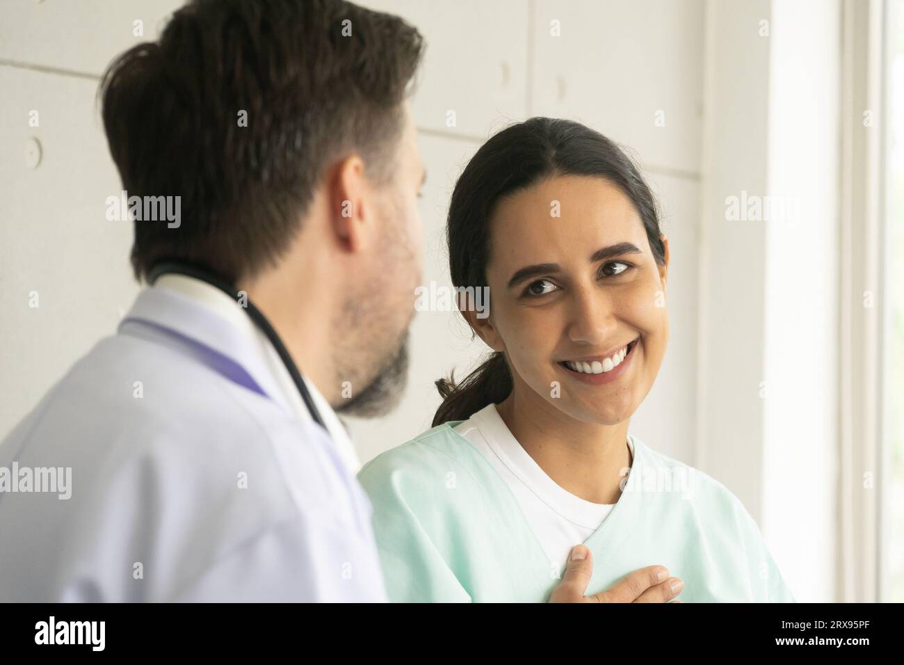 Médecin caucasien relaxant avec une patiente hispanique. L'examen médical et le bilan de santé avec le concept de médecin. Banque D'Images