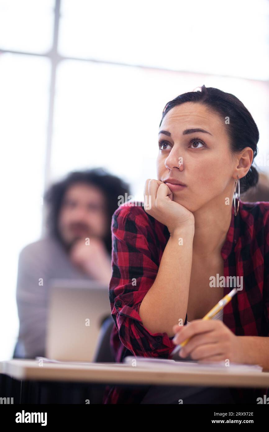 Les élèves écoutent un conférencier dans une salle de classe.Des jeunes intelligents étudient à l'université. Banque D'Images