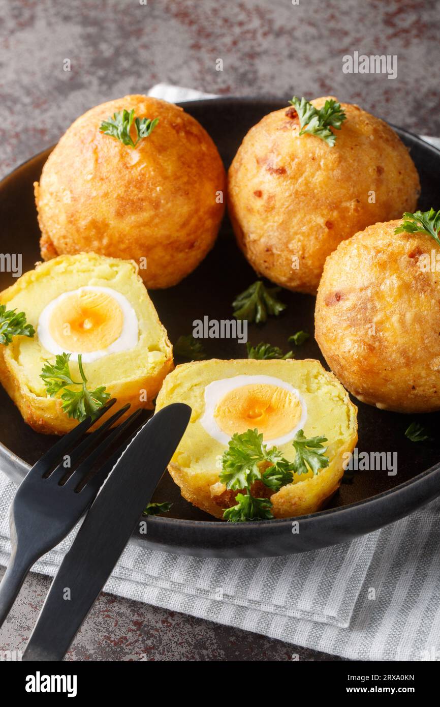 Boules d'œufs de manioc Guyanais gros plan sur l'assiette sur la table. Vertical Banque D'Images