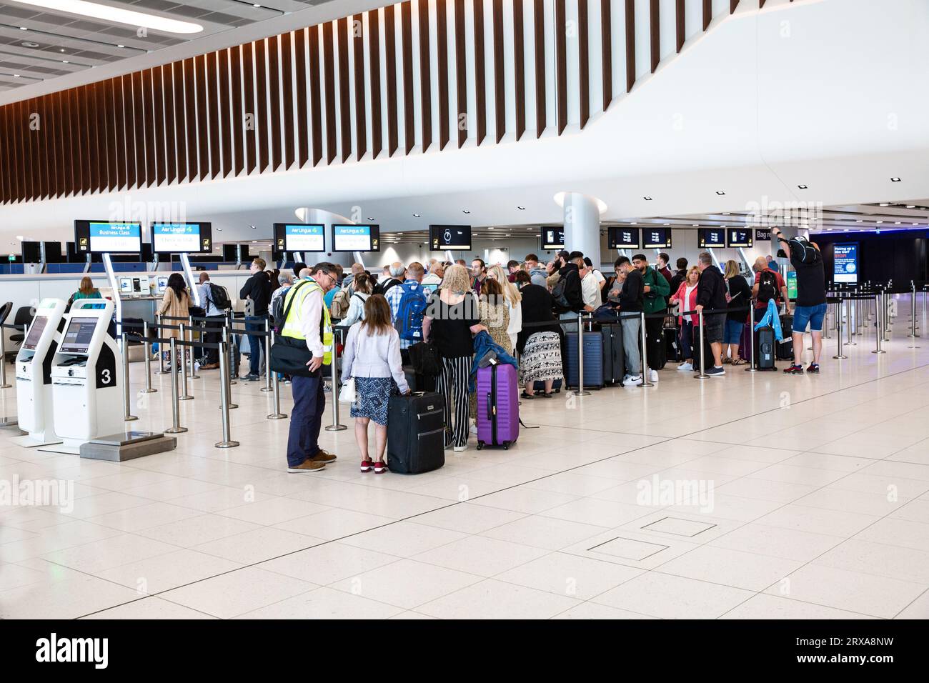 TERMINAL 2, AÉROPORT DE MANCHESTER, ROYAUME-UNI - 14 SEPTEMBRE 2023. Passagers aériens et voyageurs faisant la queue pour l'enregistrement et dépôt des bagages au nouveau loun de départ Banque D'Images