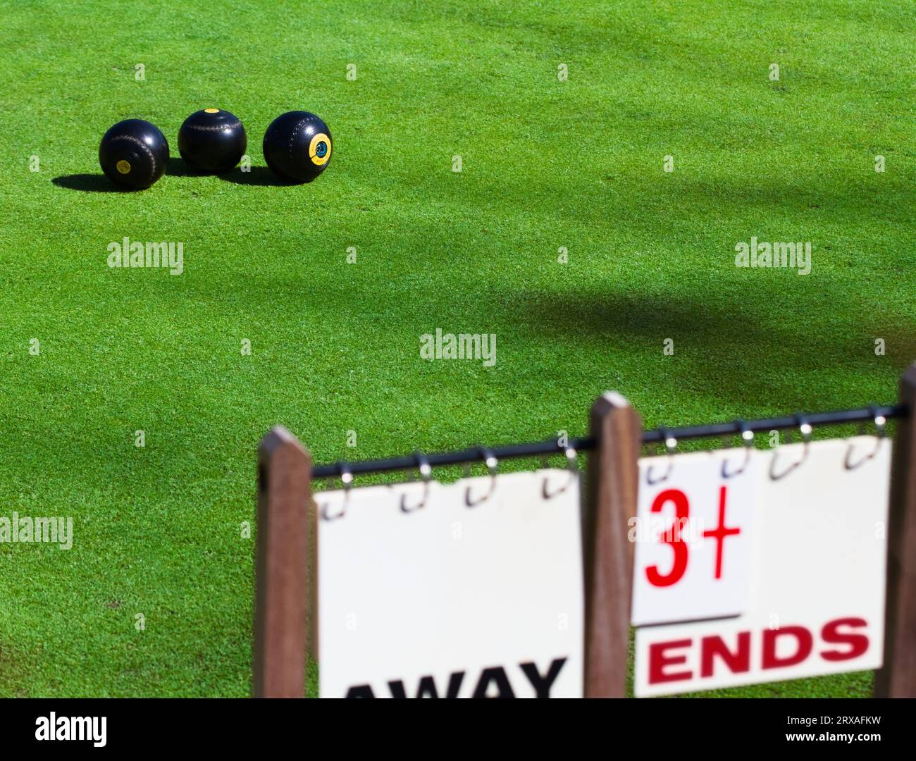 Trois Lawn Bowls sur Un Bowling Green avec le tableau de bord dans The Foreground, Highcliffe, Royaume-Uni Banque D'Images