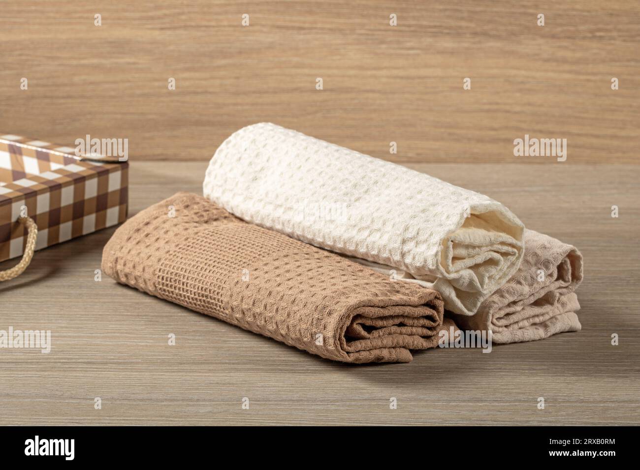 Serviettes gaufrées roulées dans un rouleau sont empilées sur une table en bois, vue de dessus, vie domestique Banque D'Images