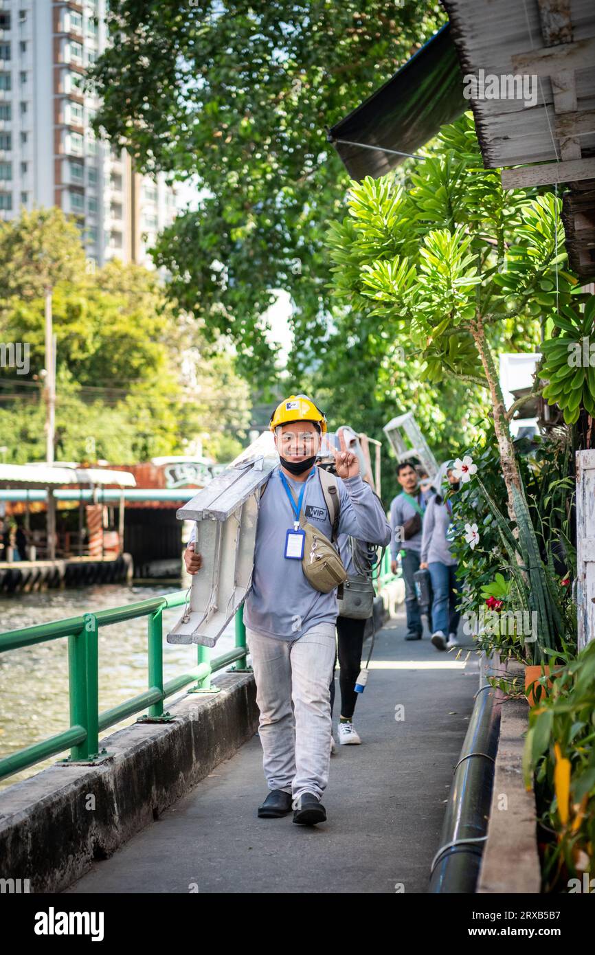 Certains ouvriers de la construction très joyeux sourient pour mon appareil photo alors qu'ils marchent le long du chemin du canal Saen SAEP, Bangkok, Thaïlande. Banque D'Images