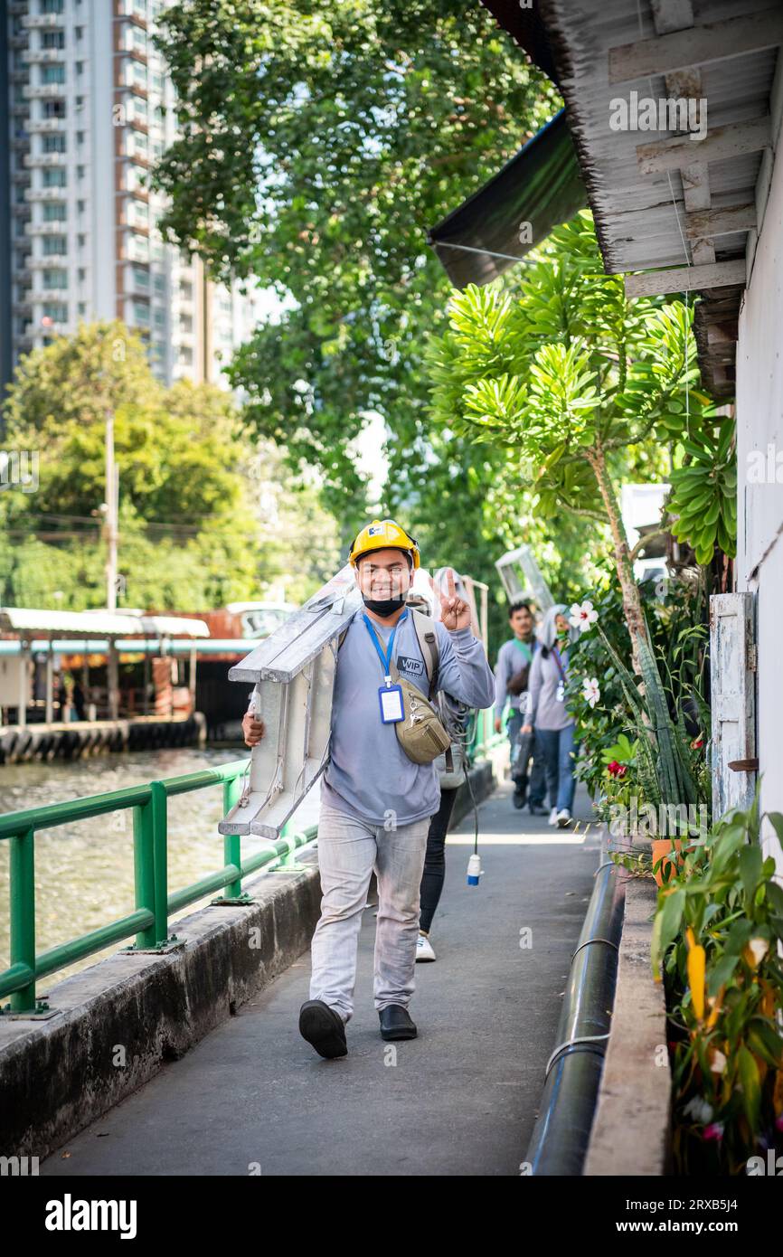Certains ouvriers de la construction très joyeux sourient pour mon appareil photo alors qu'ils marchent le long du chemin du canal Saen SAEP, Bangkok, Thaïlande. Banque D'Images