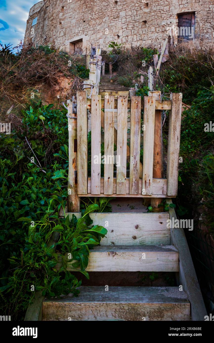 Marches en bois usagées et porte menant à une ancienne forteresse en pierre Banque D'Images