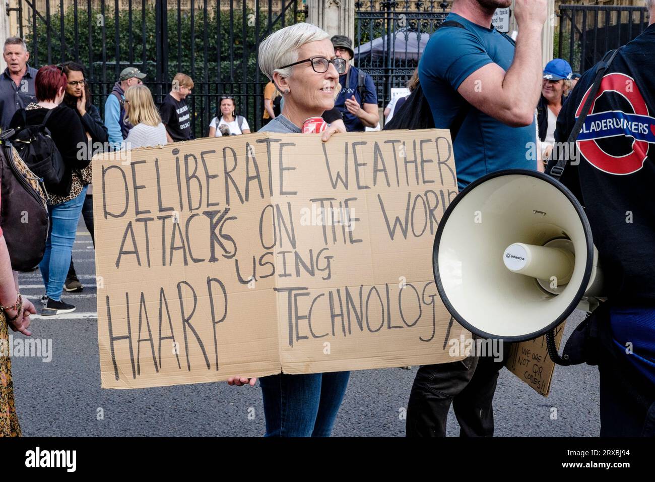 Une femme tient une pancarte affirmant que la technologie HAARP est utilisée pour manipuler les attaques météorologiques sur le monde. Londres Royaume-Uni. Banque D'Images