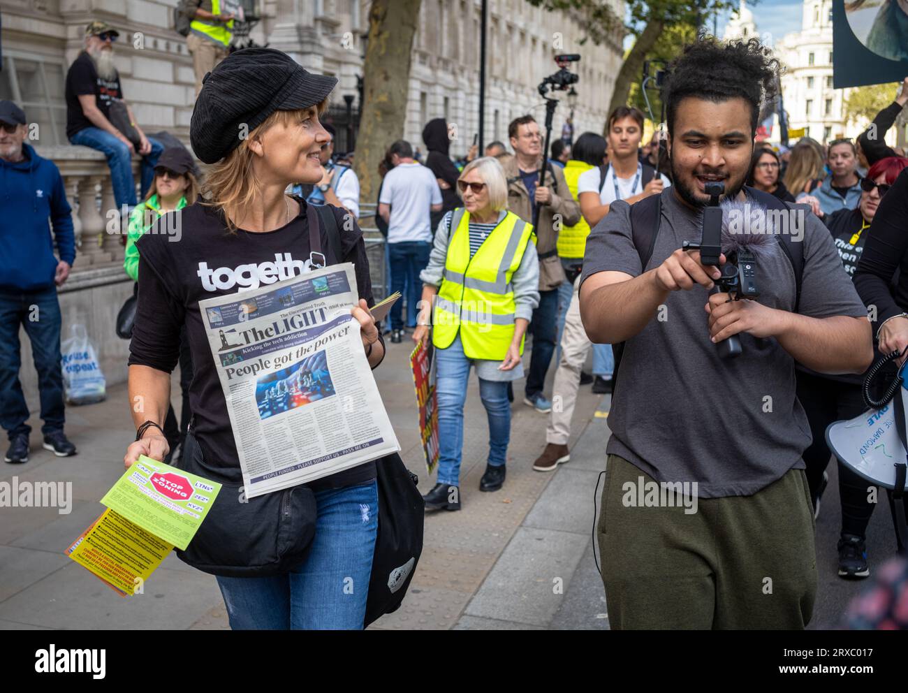 Une femme distribue le journal des théoriciens du complot, The Light, et d'autres tracts lors d'une manifestation à Whitehall, Londres, par des théoriciens du complot Banque D'Images