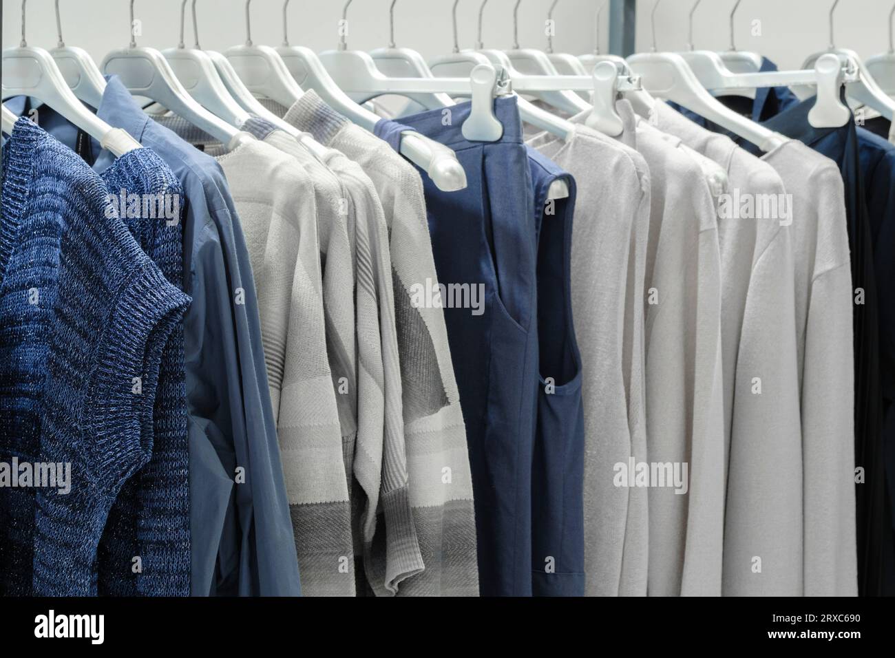 Vêtements de famille bleus et blancs sur cintres en magasin Banque D'Images