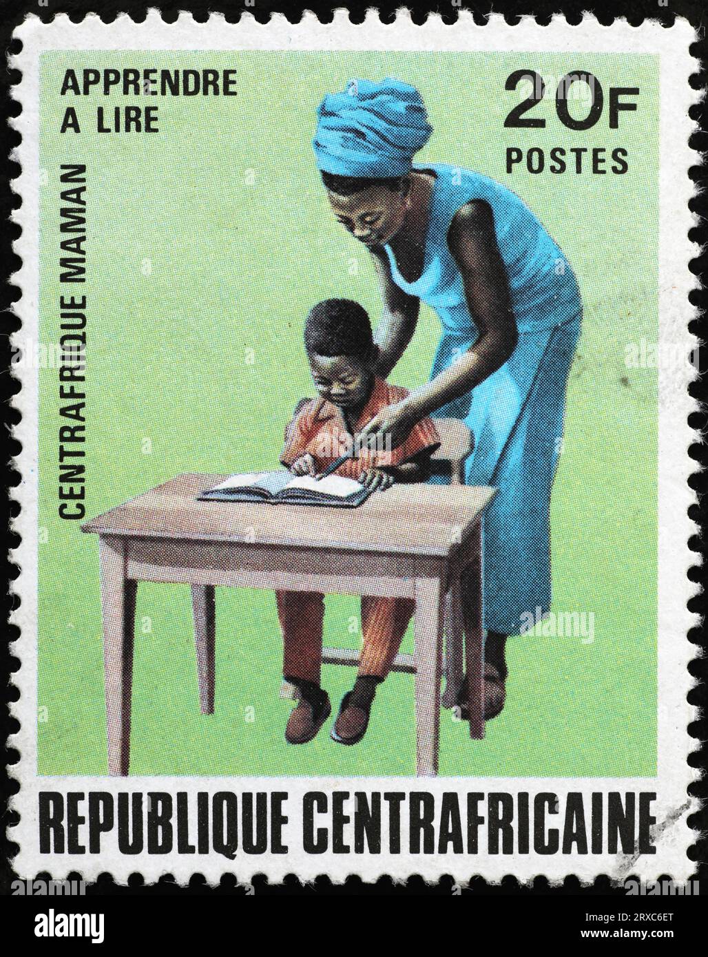 Garçon apprenant à lire sur le timbre-poste africain Banque D'Images