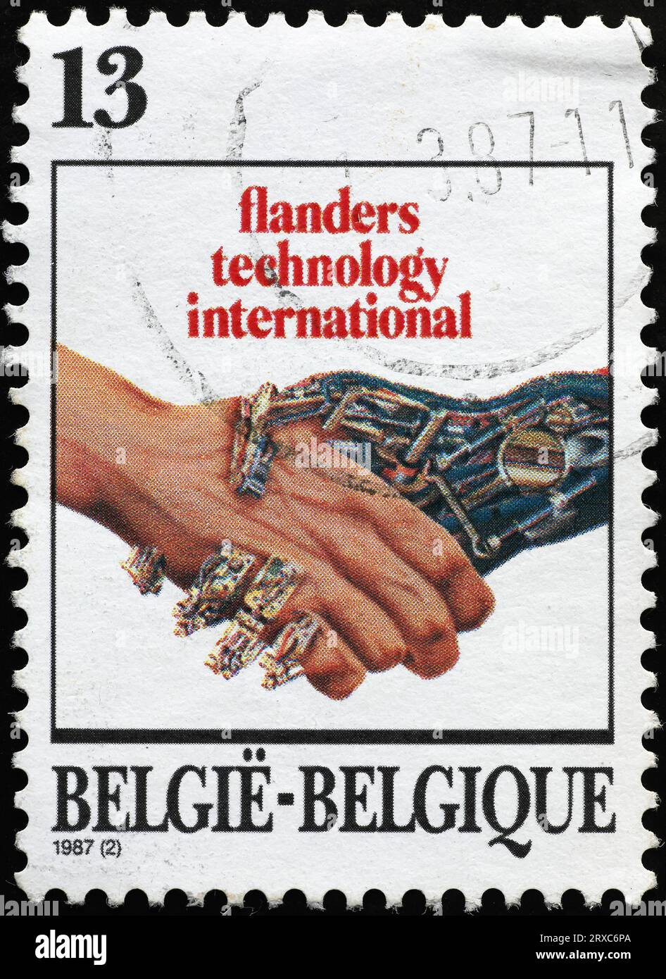 Main humaine secouant une main robotisée sur un timbre-poste Banque D'Images