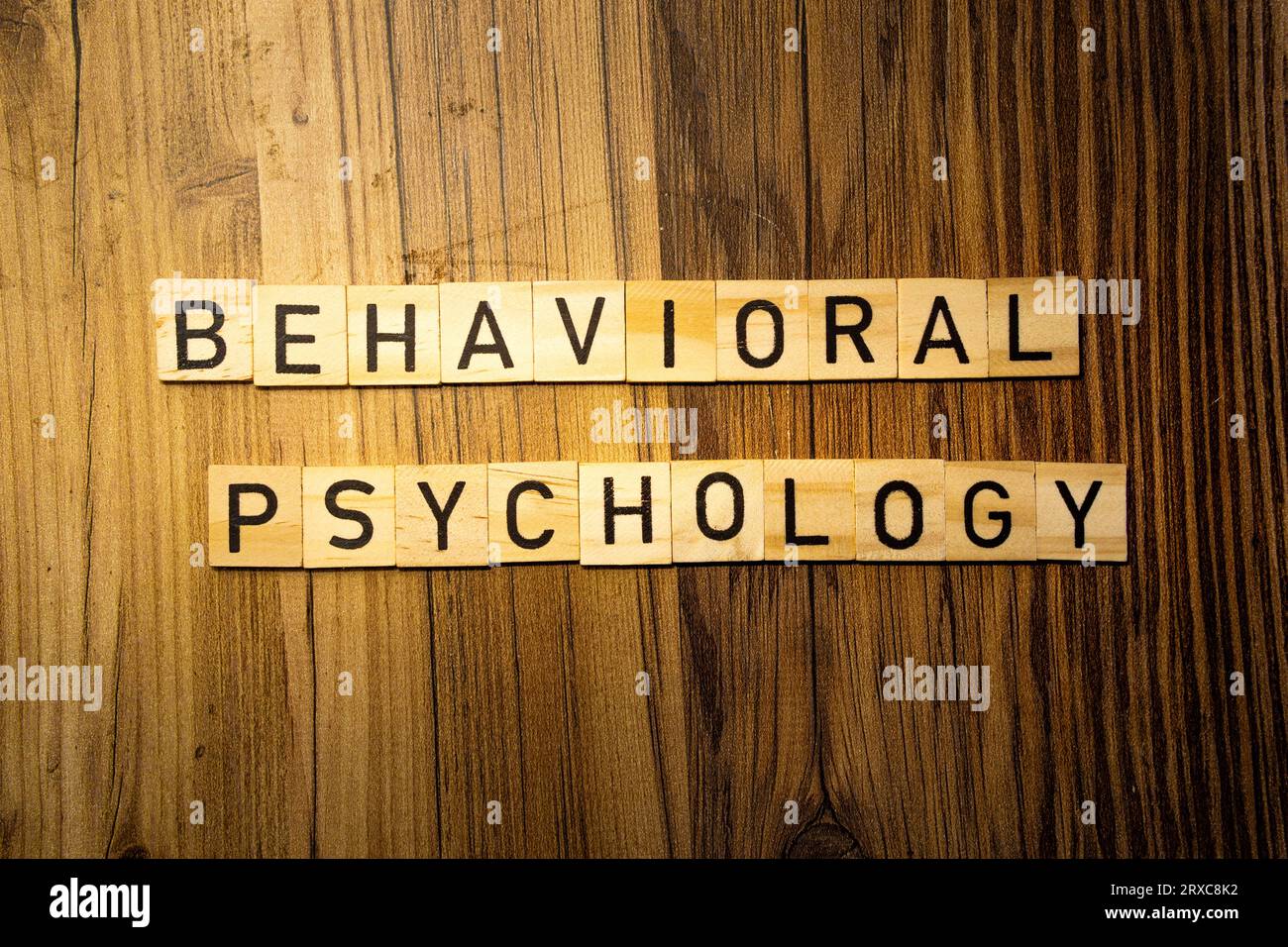 Mot concept de psychologie comportementale en lettres en bois sur fond de bois foncé Banque D'Images