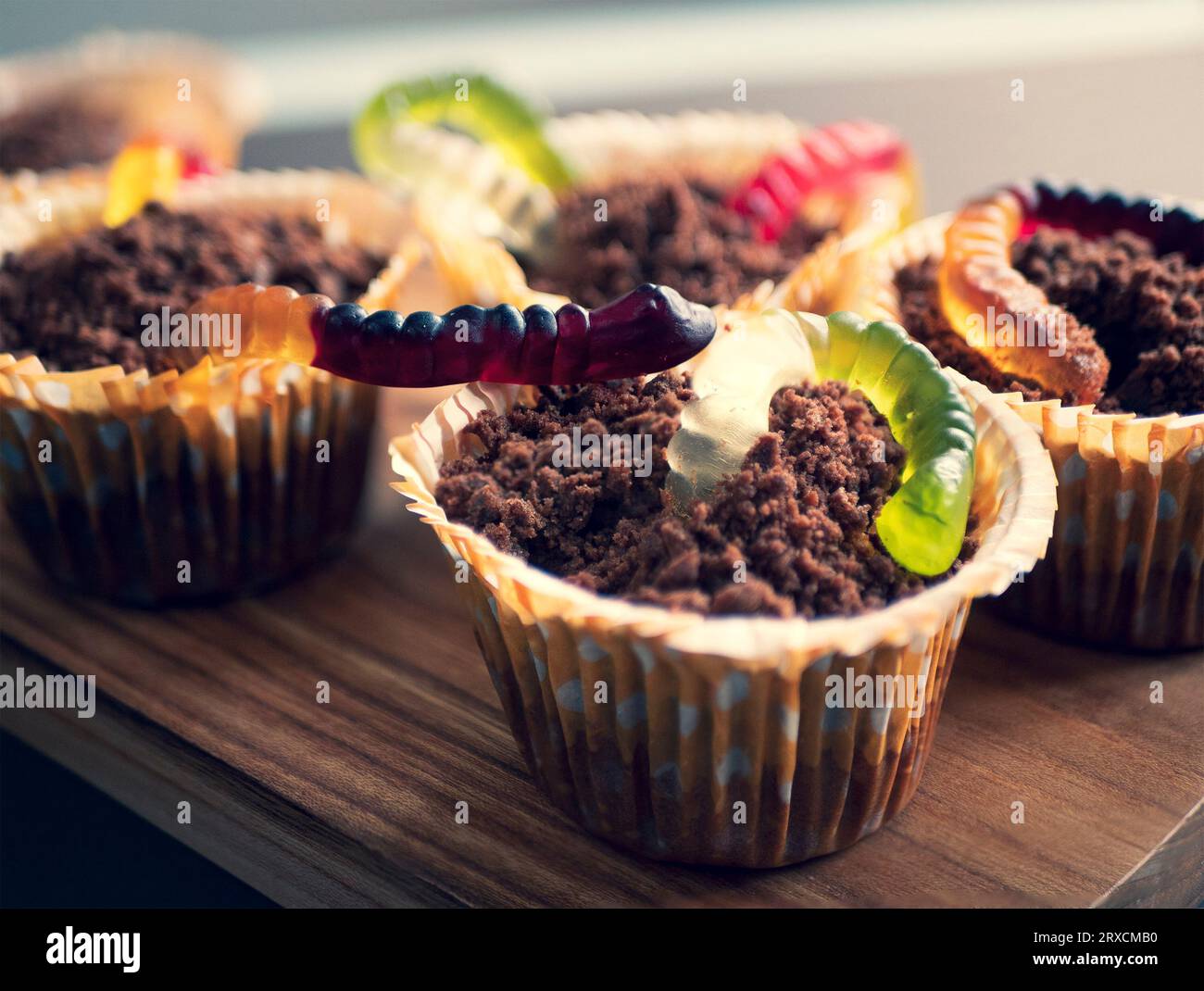 Cupcakes au chocolat doux Halloween avec des gelées rappelant les vers dans le sol, gros plan. Nourriture pour fête d'enfants Banque D'Images