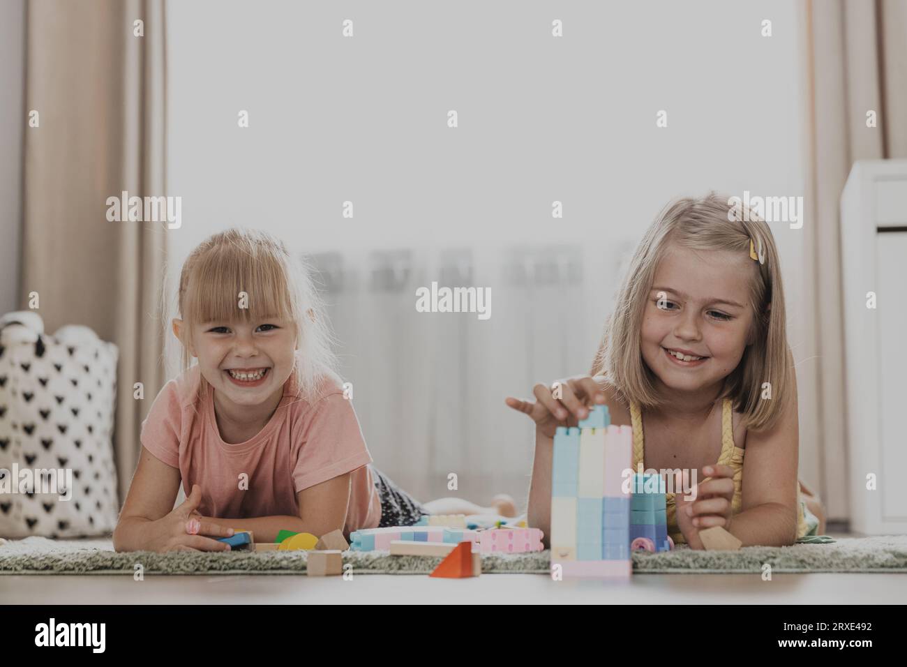 Enfants jouant avec des jouets colorés. Enfants couchés sur tapis à la chambre à coucher ou maternelle, garderie. Jeu écologique éducatif pour enfant. Créatif Banque D'Images