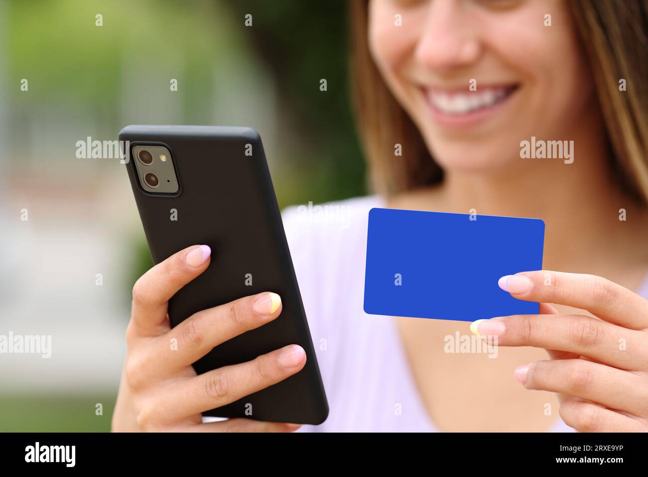 Gros plan d'un heureux adolescent mains achetant en ligne avec carte de crédit et téléphone intelligent à l'extérieur Banque D'Images
