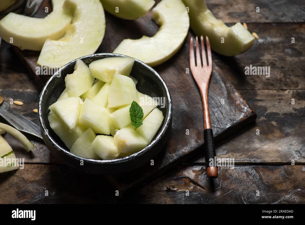 Melon gaya ivoire avec des rayures pointillées vertes et des taches sur un fond en bois. Fruits mûrs colorés, juteux et mous, goût sucré avec des notes florales. Fruits Banque D'Images