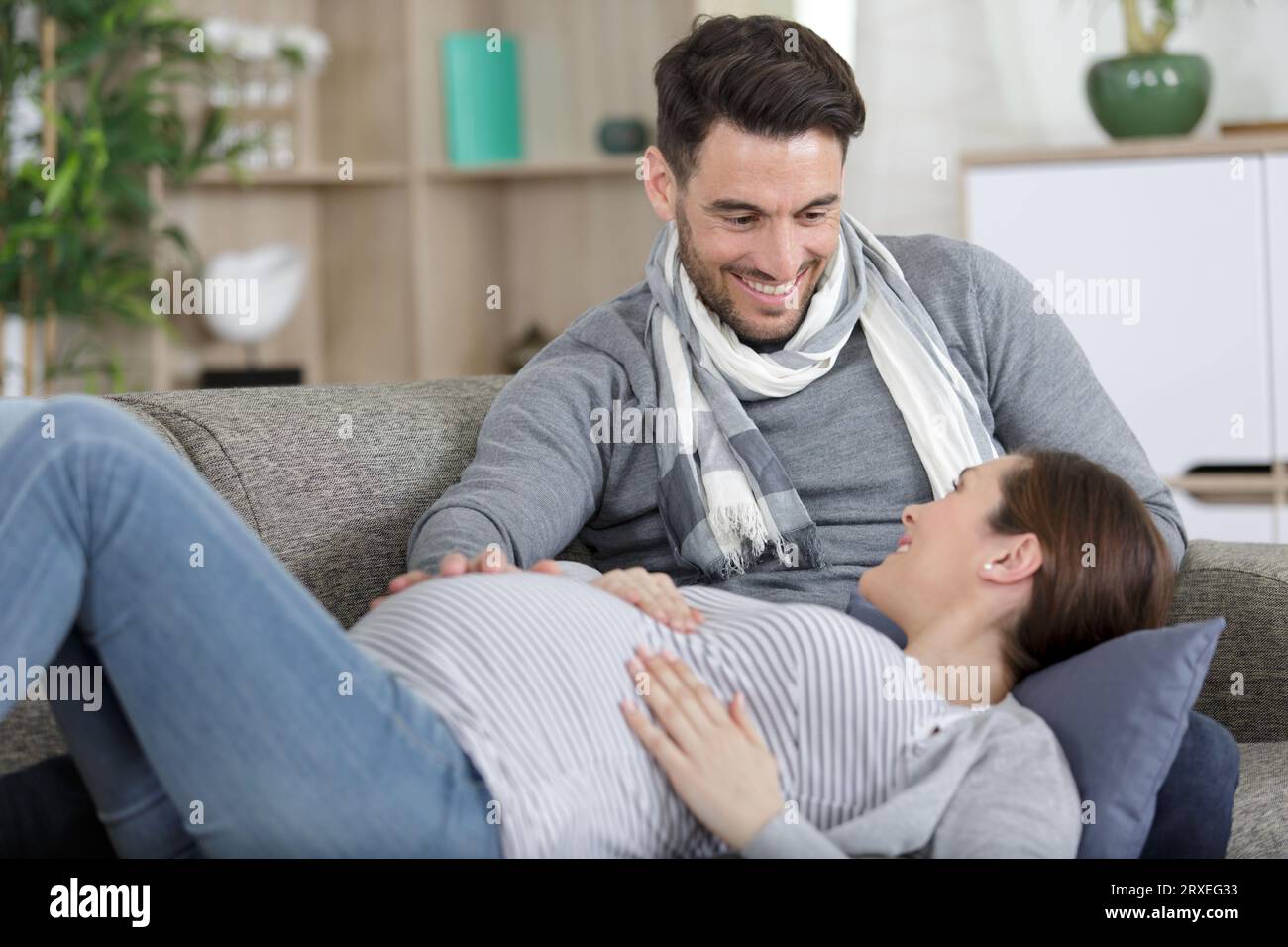 femme enceinte et bel homme allongé sur le canapé Banque D'Images