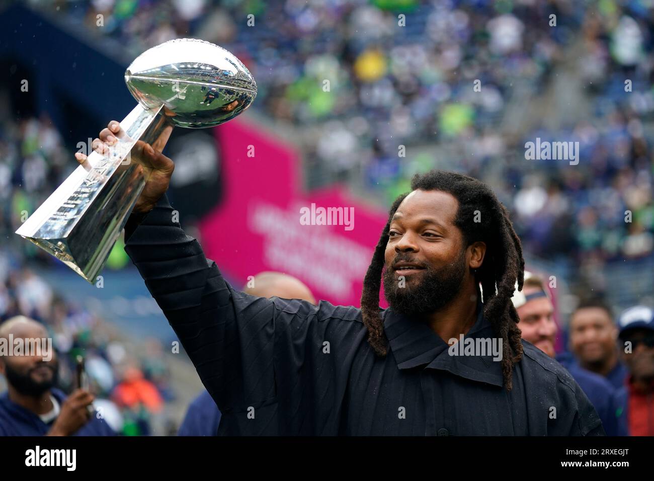 Former Seattle Seahawks player Michael Bennett holds up the Vince Lombardi trophy as members of the Super Bowl XLVIII-winning team gather for a 10-year anniversary celebration during halftime of an NFL football game against the Carolina Panthers, Sunday, Sept. 24, 2023, in Seattle. The Seahawks won 37-27. (AP Photo/Lindsey Wasson) Banque D'Images