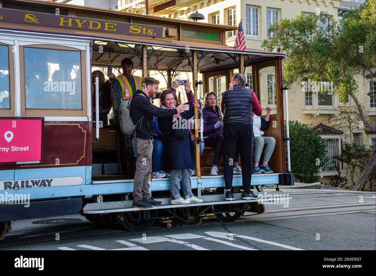 Touristes prenant des selfies à bord d'un téléphérique de San Francisco, Californie, USA Banque D'Images