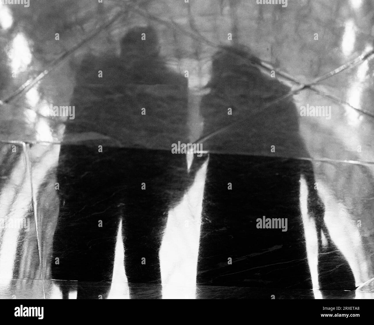 Un reflet d'un couple découpé se tenant la main. Banque D'Images