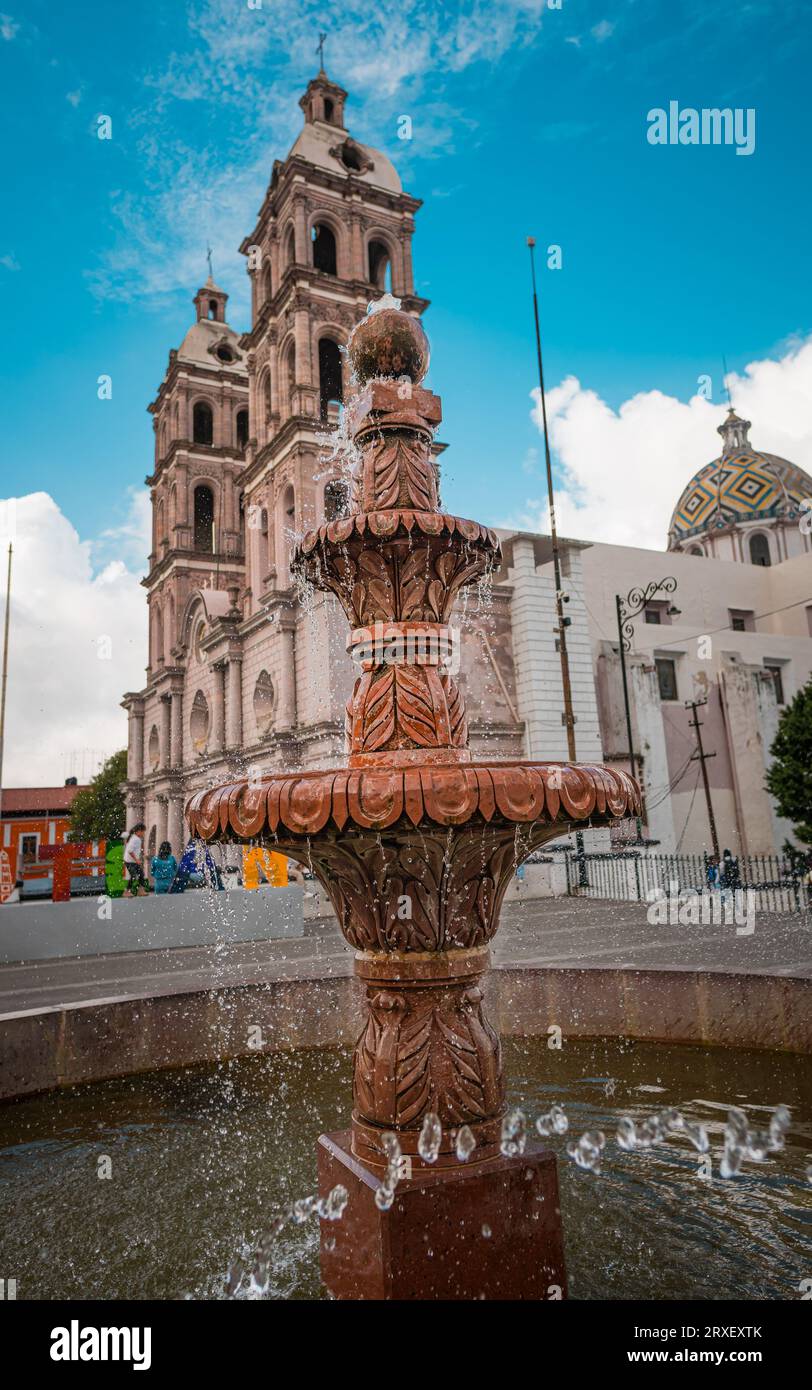 Fontaine avec de l'eau en mouvement avec une cathédrale en arrière-plan. Banque D'Images