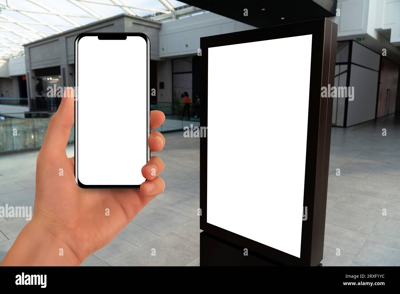 Main avec le téléphone sur un fond de kiosque libre-service dans le centre commercial. Banque D'Images