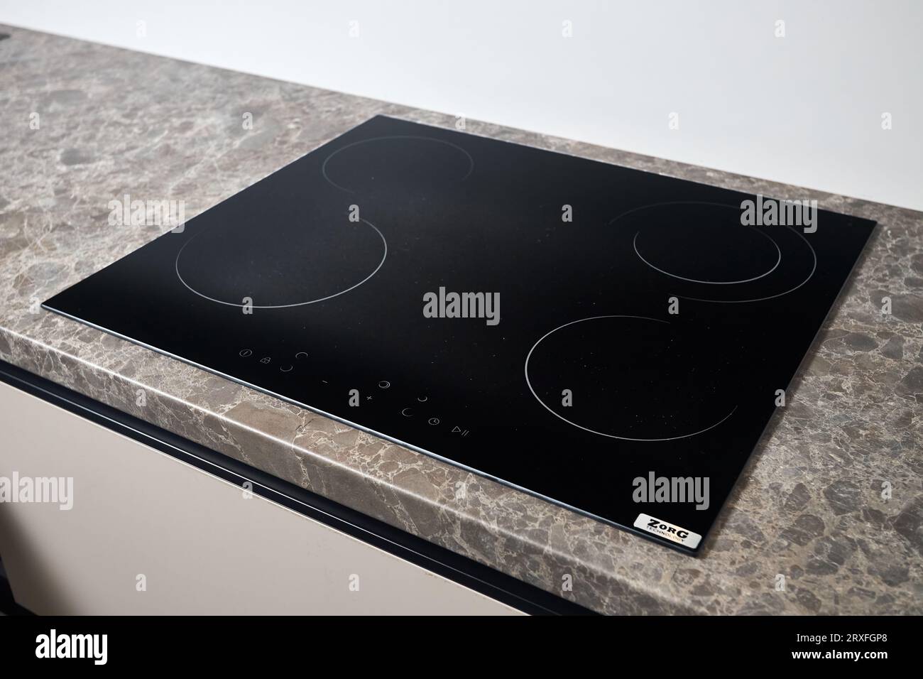 Plaque de cuisson plate à induction cuisinière électrique construite noire. Comptoir beige gris avec noir brillant construit en céramique à induction en verre trempé ou Banque D'Images