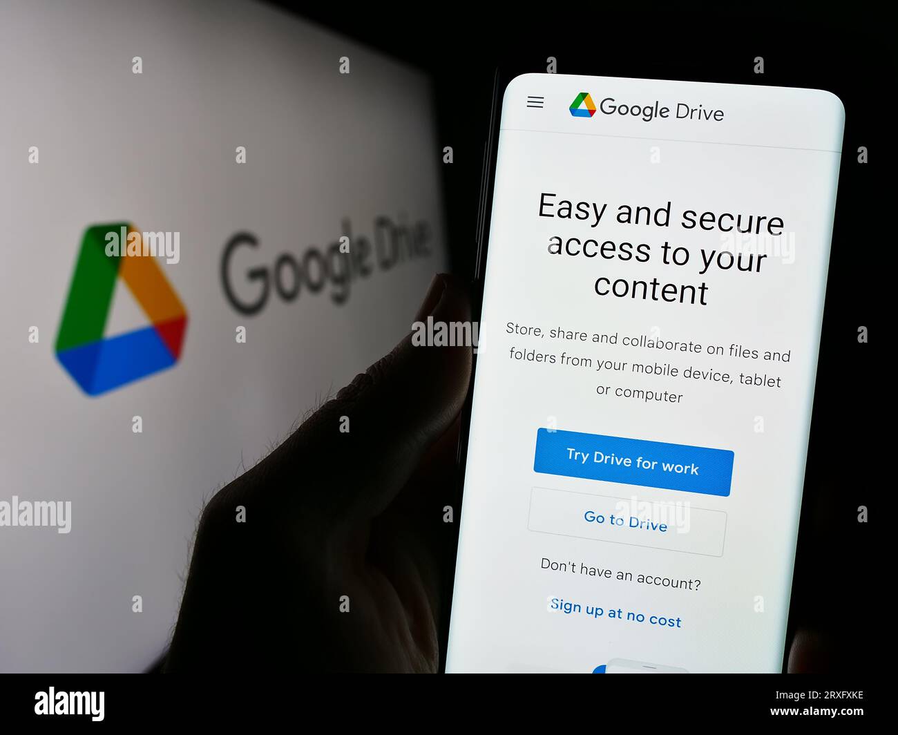 Personne tenant le téléphone portable avec la page Web de la plate-forme de stockage de fichiers Google Drive sur l'écran en face du logo. Concentrez-vous sur le centre de l'écran du téléphone. Banque D'Images