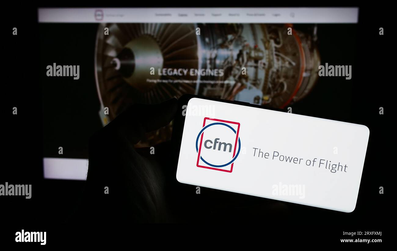 Personne tenant le téléphone portable avec le logo de la compagnie de moteurs d'avion CFM International sur l'écran devant la page Web de l'entreprise. Concentrez-vous sur l'affichage du téléphone. Banque D'Images