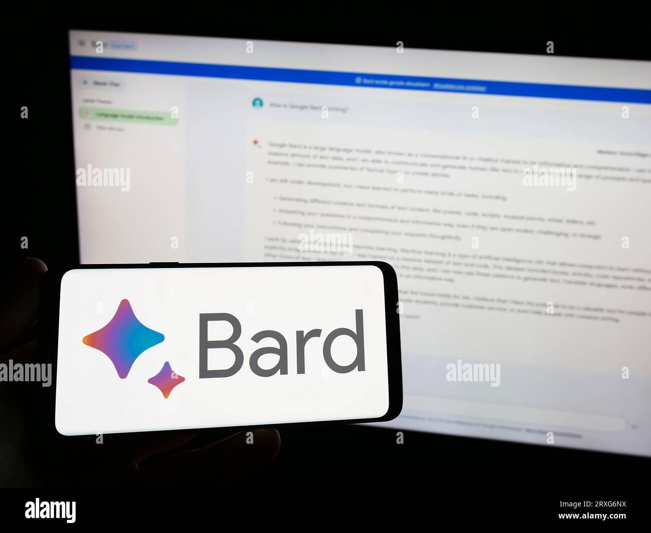 Personne tenant smartphone avec logo de chatbot génératif ai Google Bard sur l'écran en face du site Web. Concentrez-vous sur l'affichage du téléphone. Banque D'Images