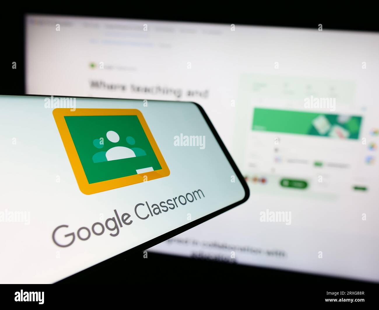Smartphone avec logo de la plate-forme d'apprentissage mixte Google Classroom sur l'écran devant le site Web de l'entreprise. Concentrez-vous sur le centre de l'écran du téléphone. Banque D'Images